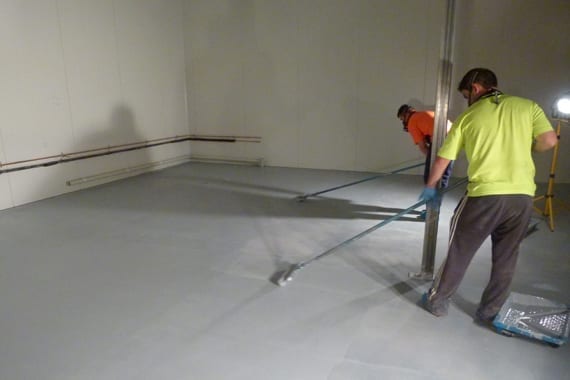 applying floor coating in freezer room