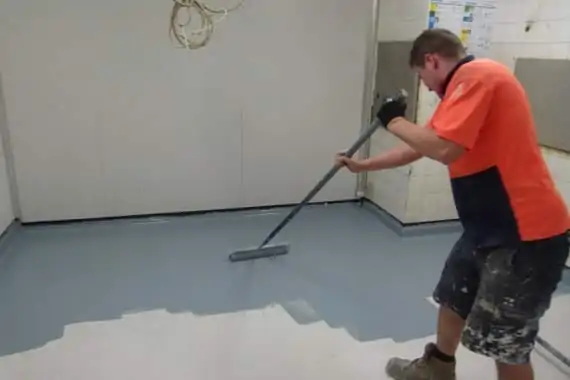 applying floor coating in freezer room